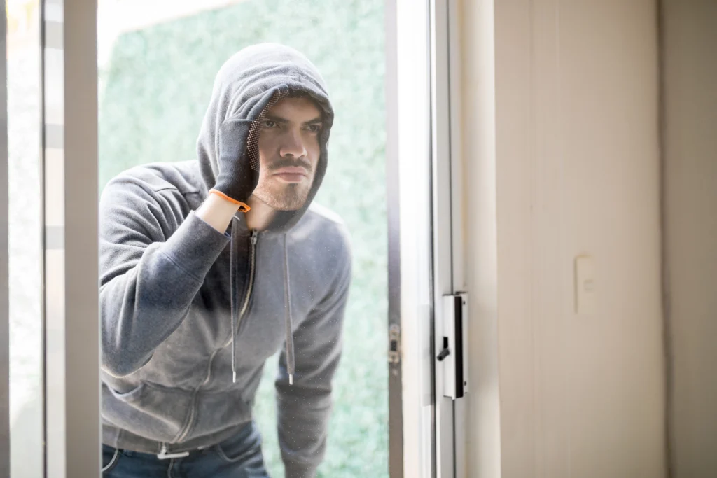 Intruder looking inside a house through a glass door